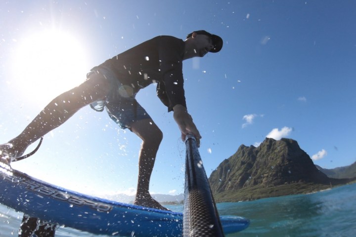 a man flying through the air while riding a snow board in the water