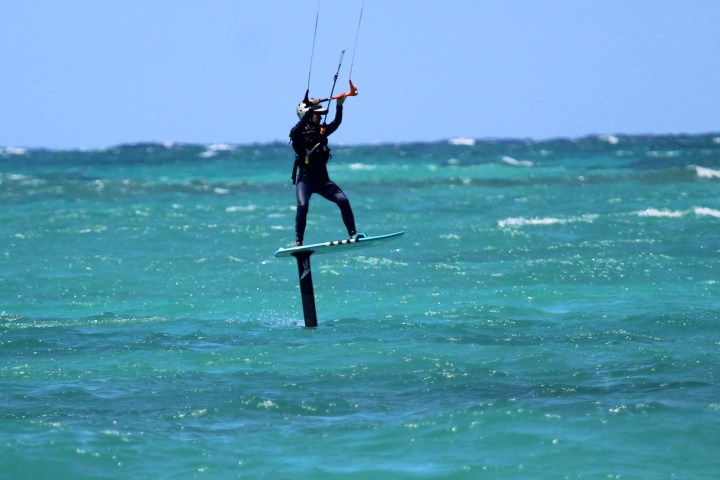 a man riding a wave on a surf board on a body of water