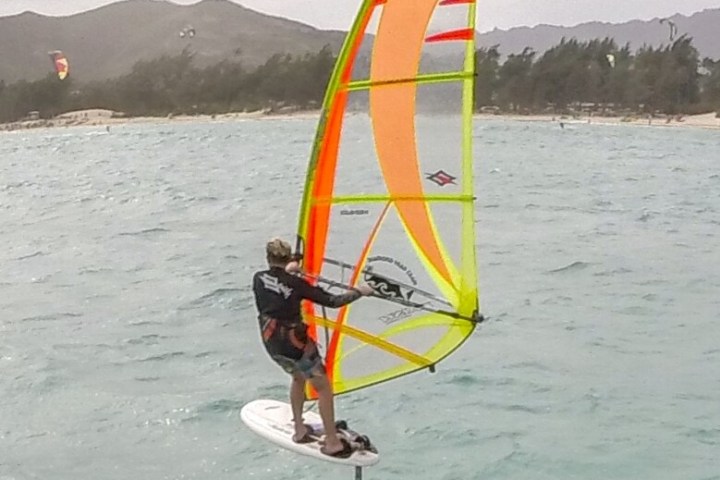 a man holding a kite in a large body of water