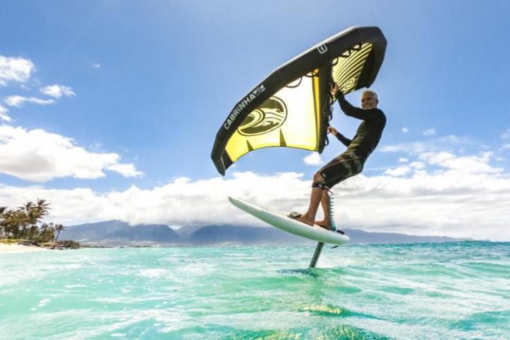 a man flying through the air while riding a wave in the ocean